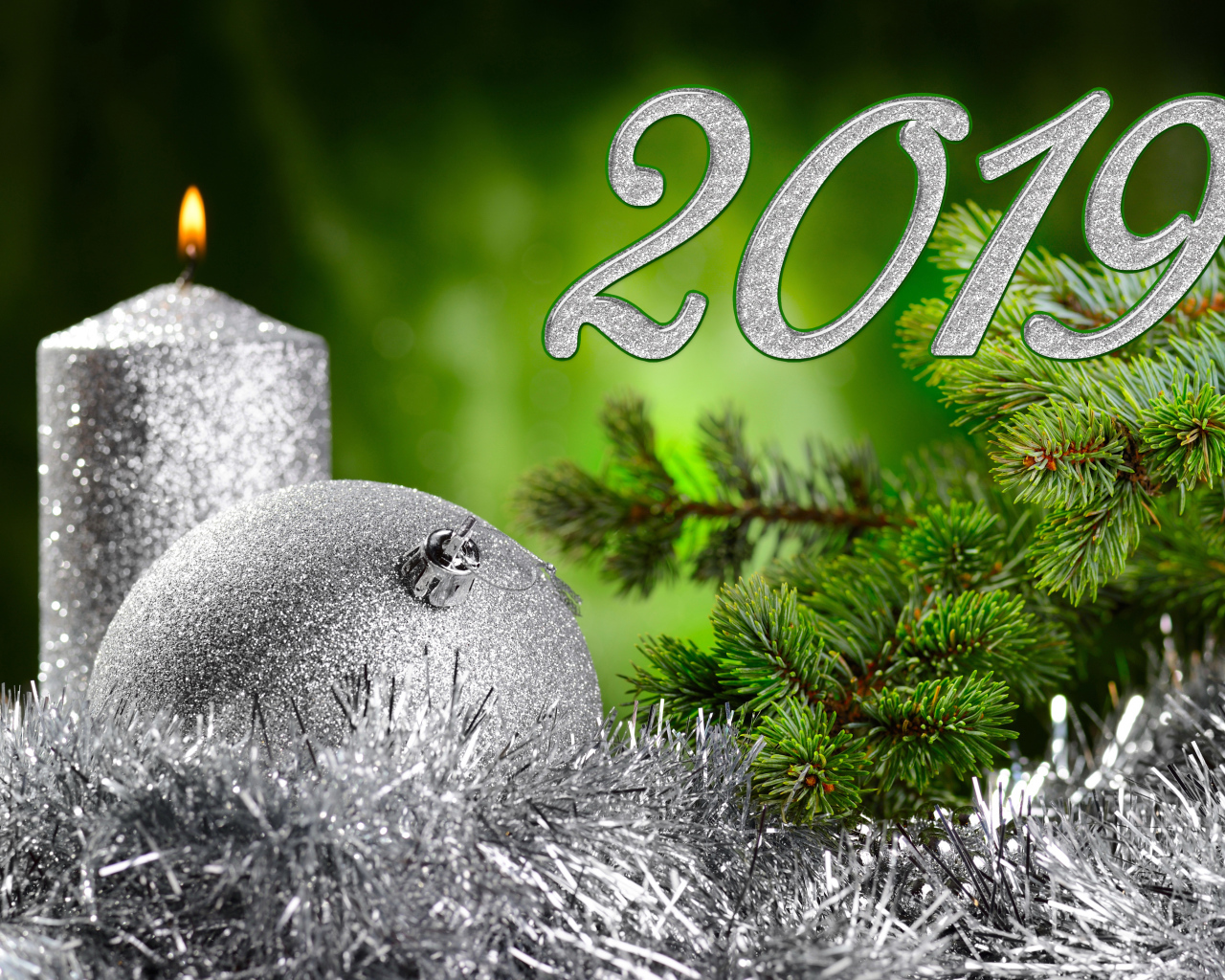 Красивый серебряный шар и свеча с еловой веткой на Новый год и Рождество 2019 