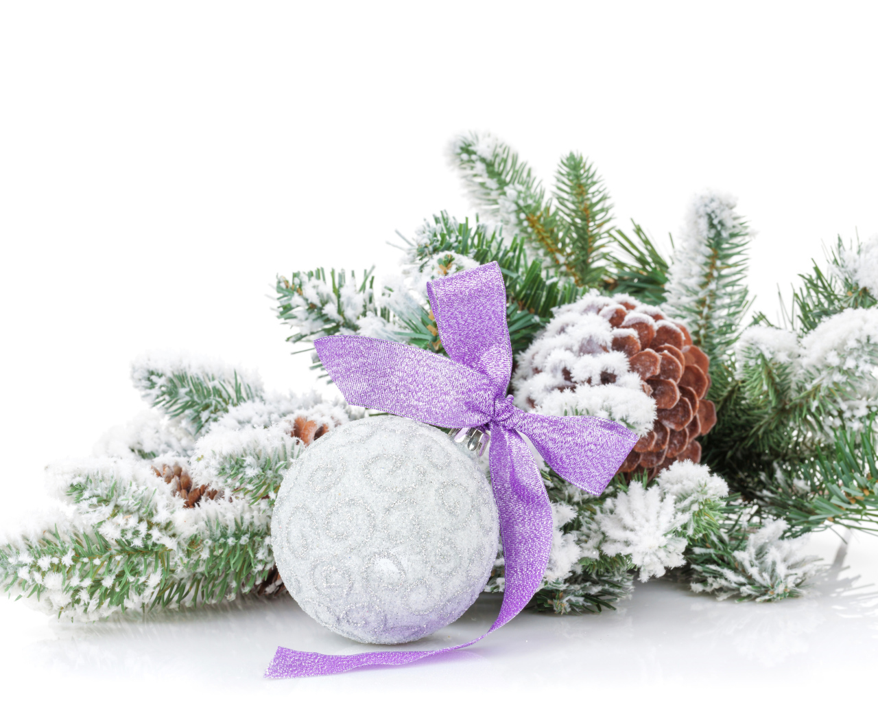 Серый елочный шар с бантом на зеленой ветке на Новый год 2019