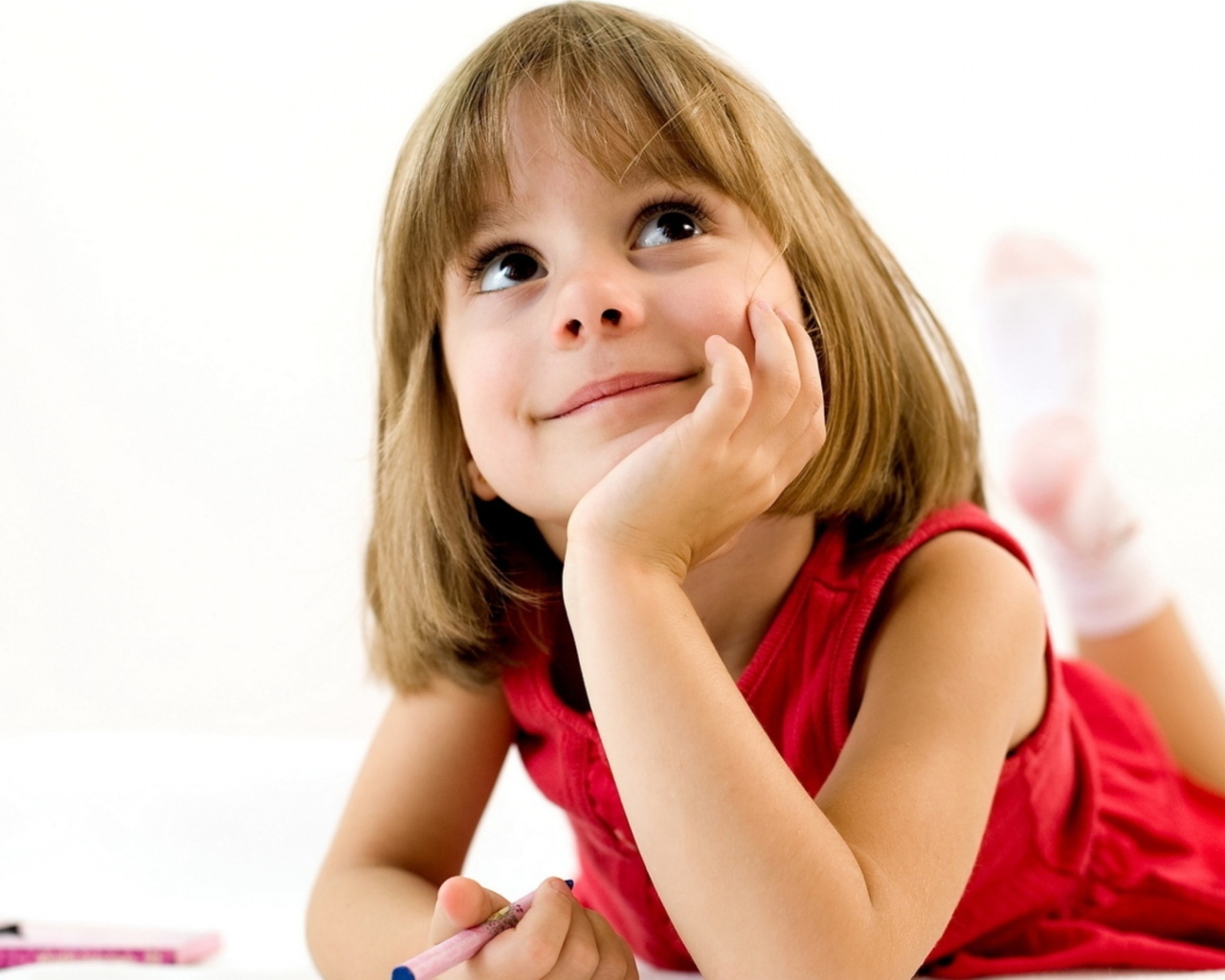 Милая девочка в красном платье рисует