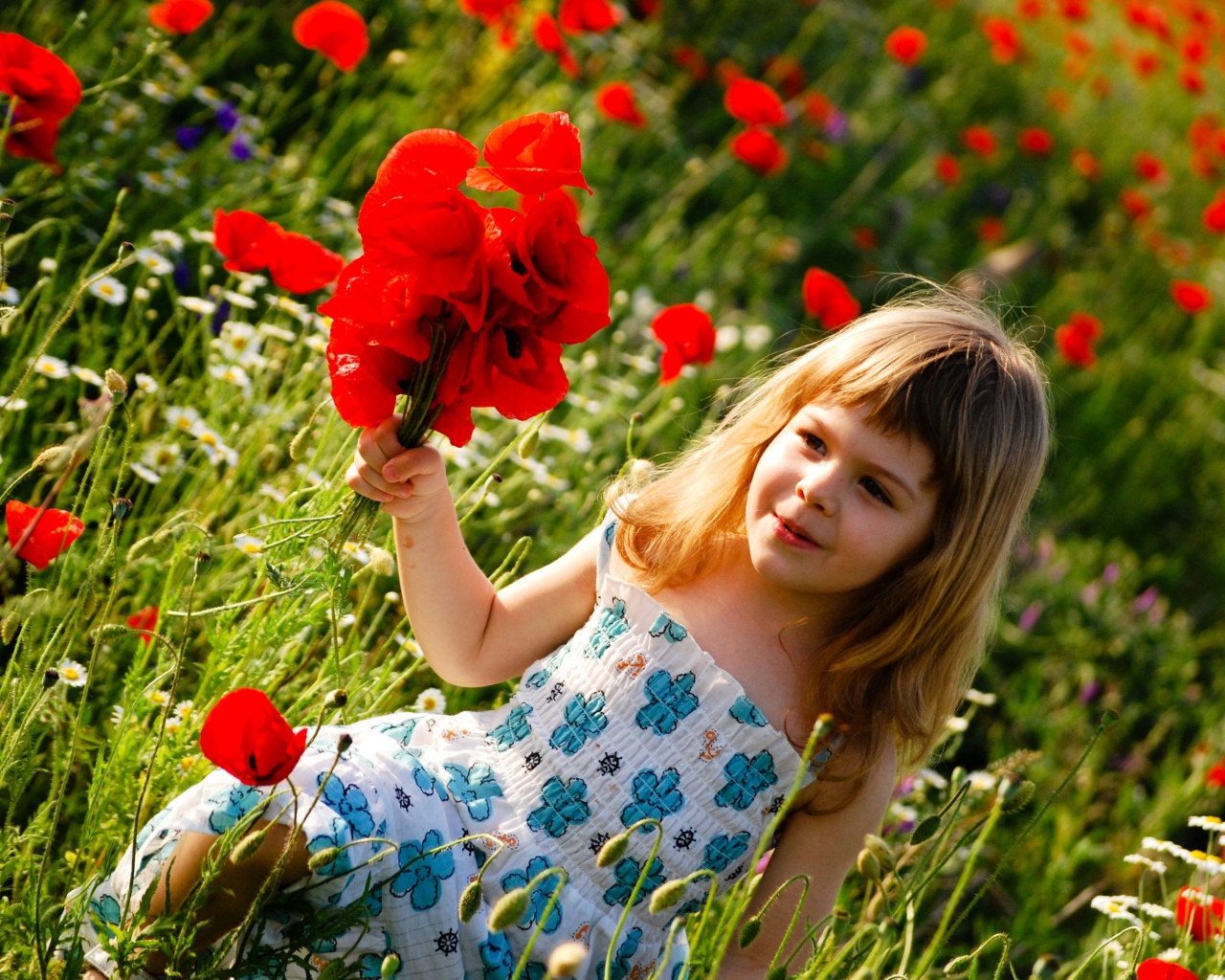 Милая маленькая девочка с букетом красных маков