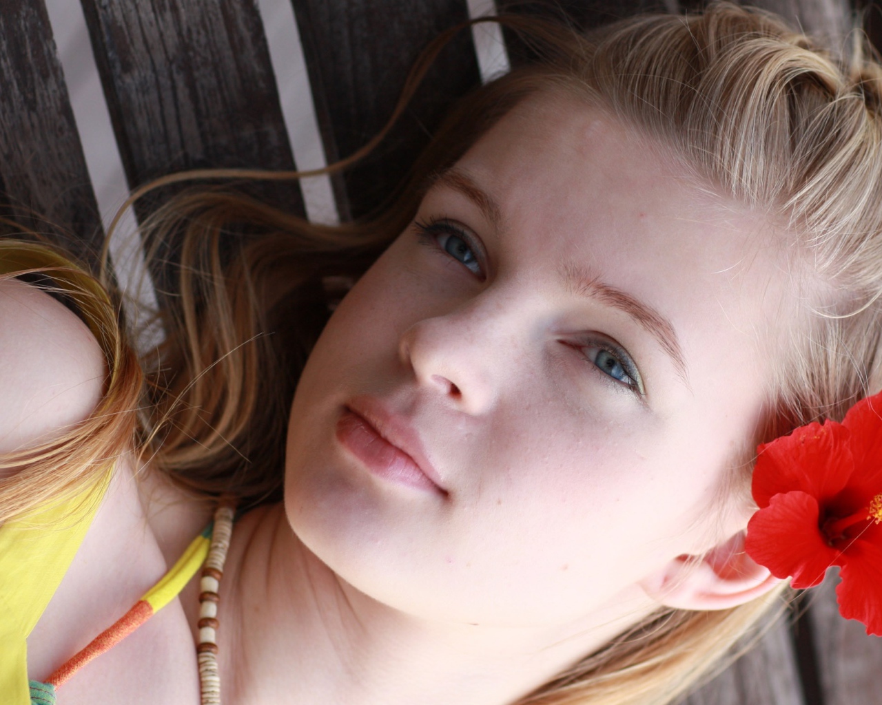 Девочка с красным цветком гибискуса в волосах