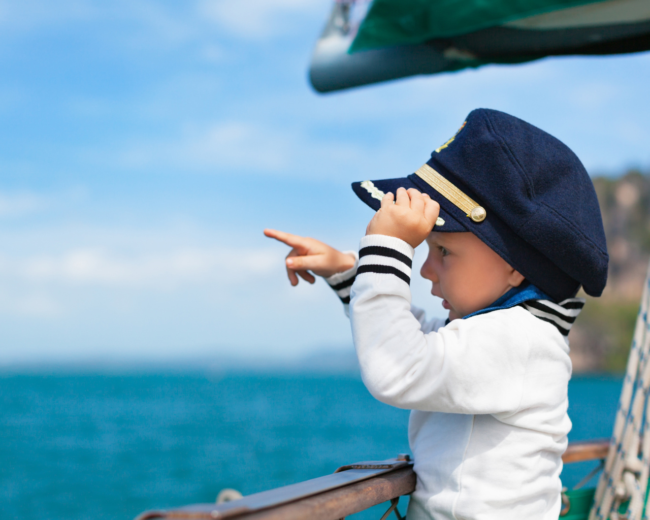 Маленький мальчик в форме капитана на корабле