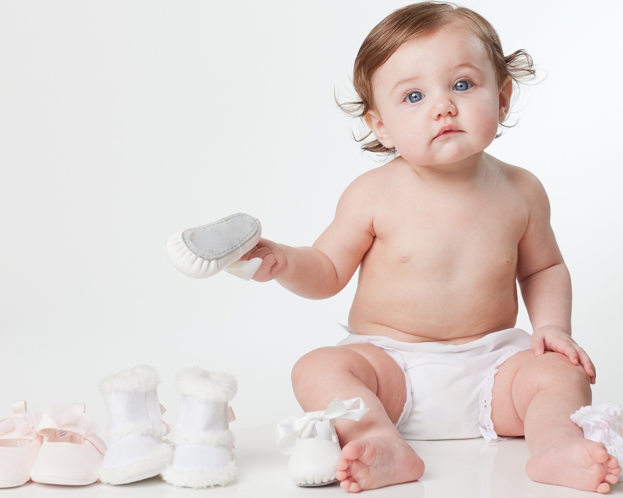 Маленький грудной ребенок с детской обувью