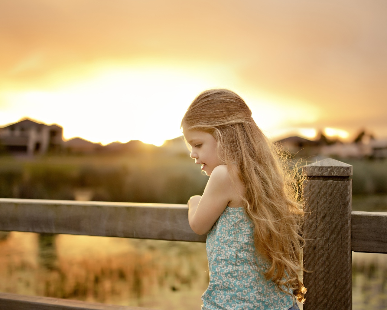 Красивая маленькая девочка на закате солнца