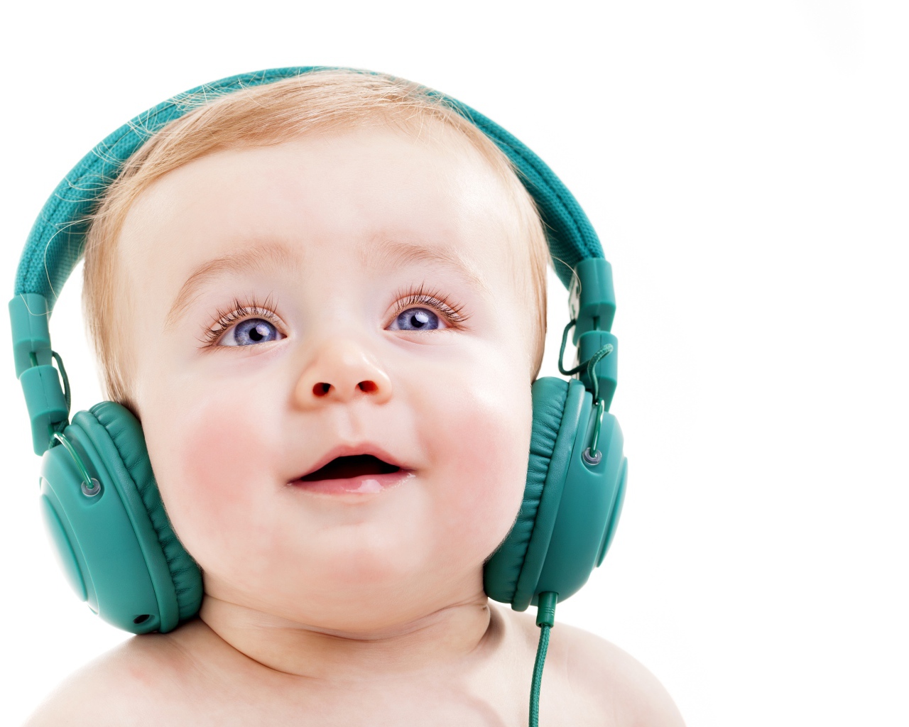 Милый младенец в больших наушниках на белом фоне