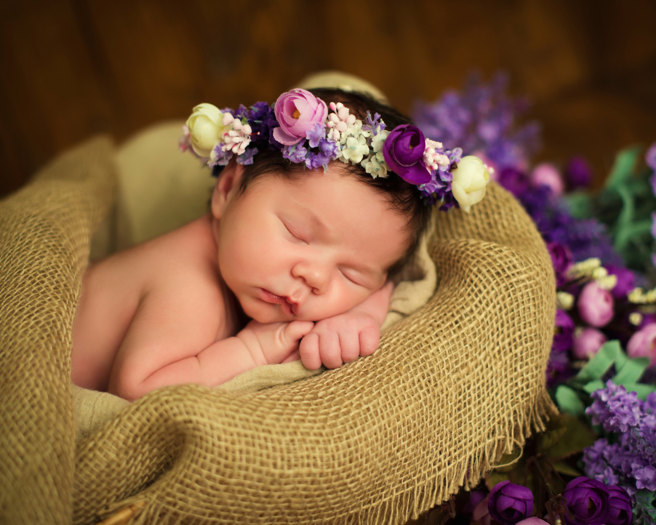 Милый спящий младенец с венком на голове