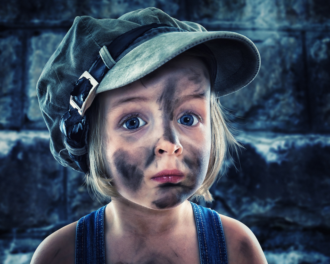 Смешная девочка в кепке с грязным лицом