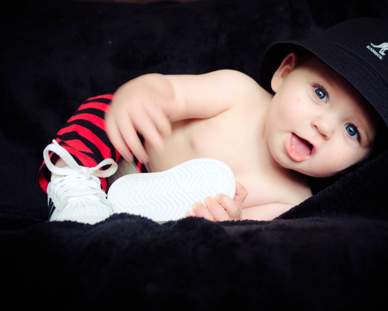 Забавный улыбающийся ребенок в черной панаме