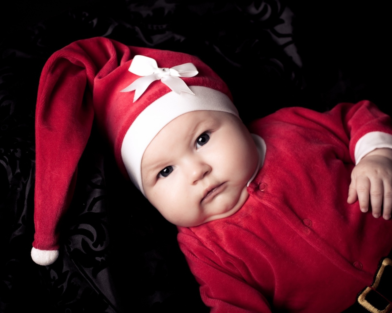 Грудной ребенок в красном новогоднем костюме