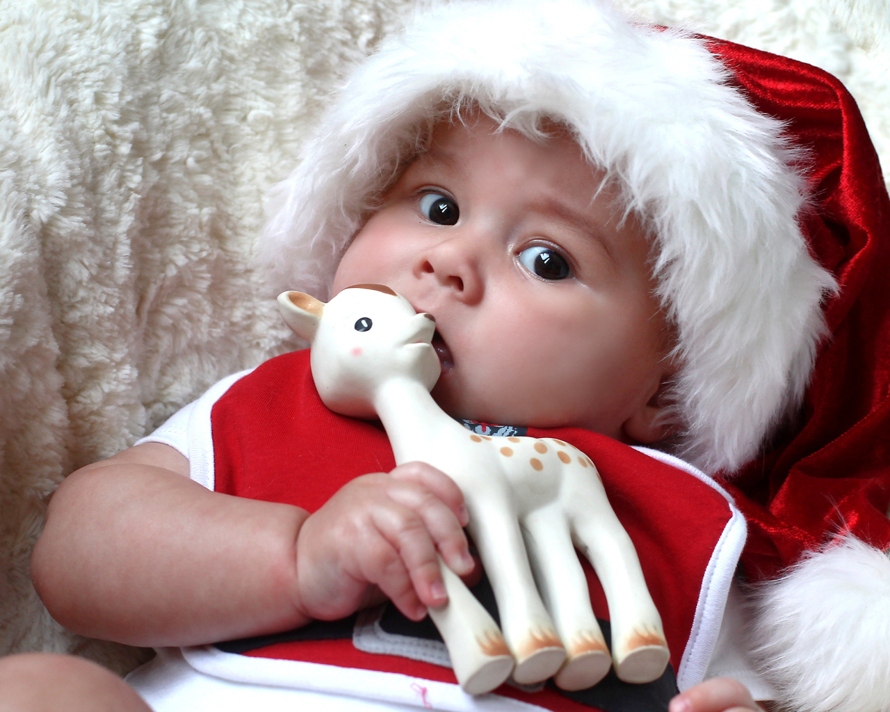 Маленький ребенок в новогодней шапке с игрушкой в руке