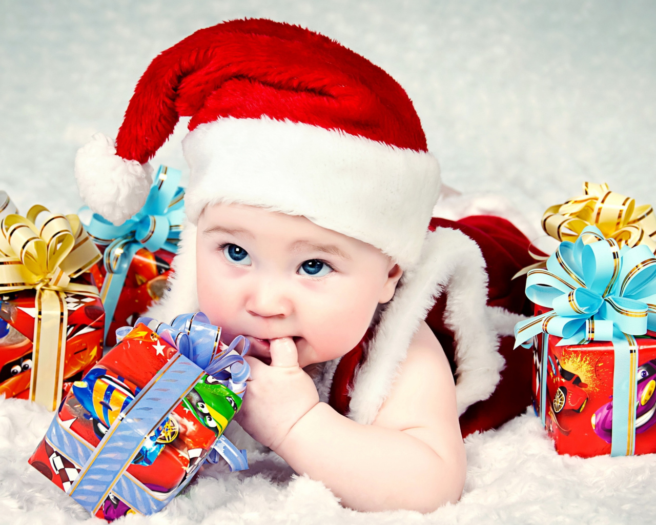 Маленький ребенок в новогоднем костюме с подарками