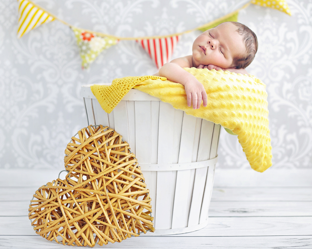 Маленький ребенок спит в корзине с плетеным сердцем