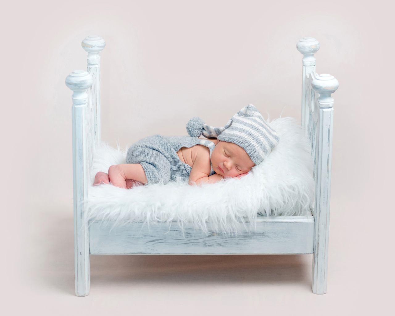 Маленький грудной ребенок спит в маленькой кроватке