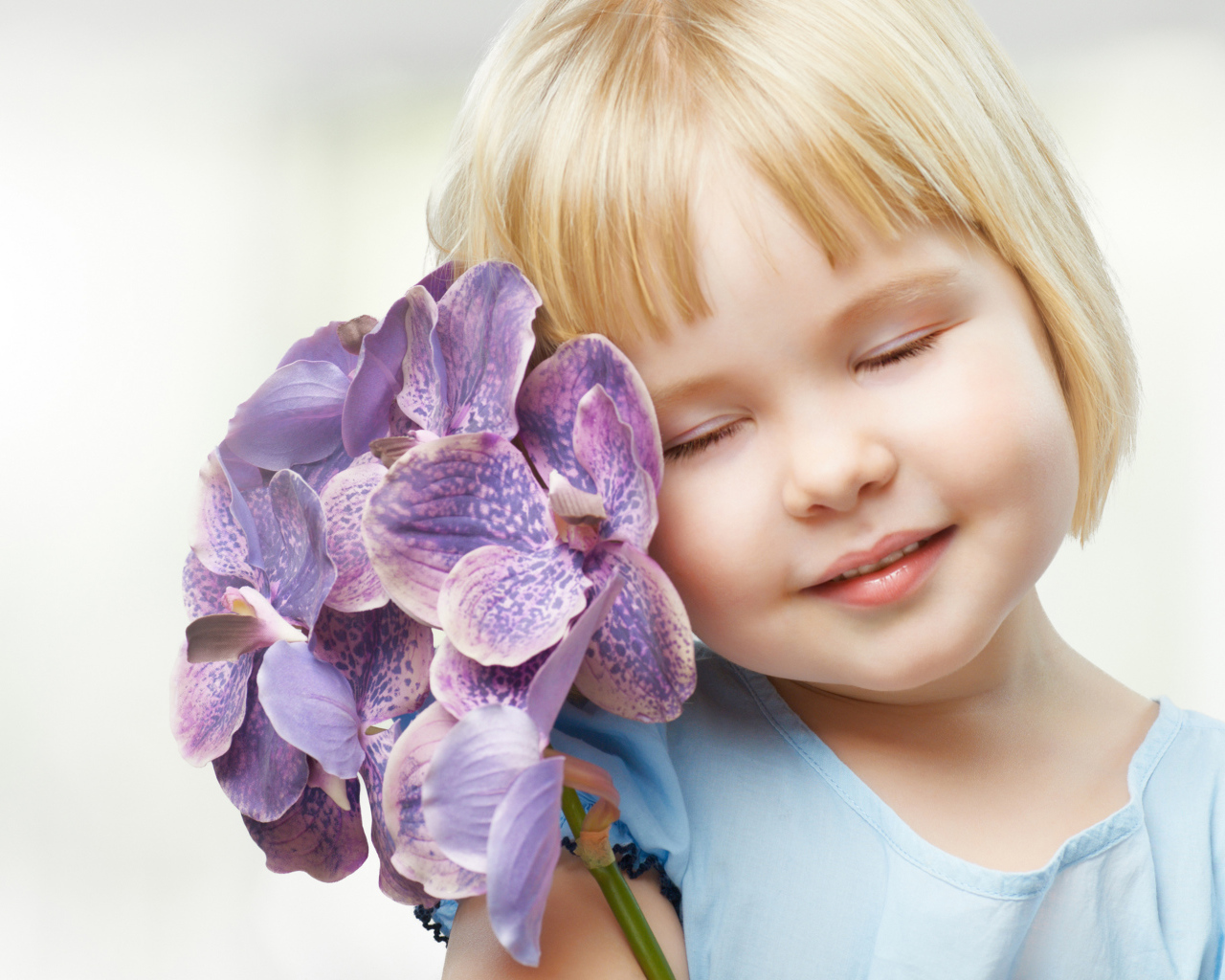 Маленькая девочка блондинка с цветами орхидеи