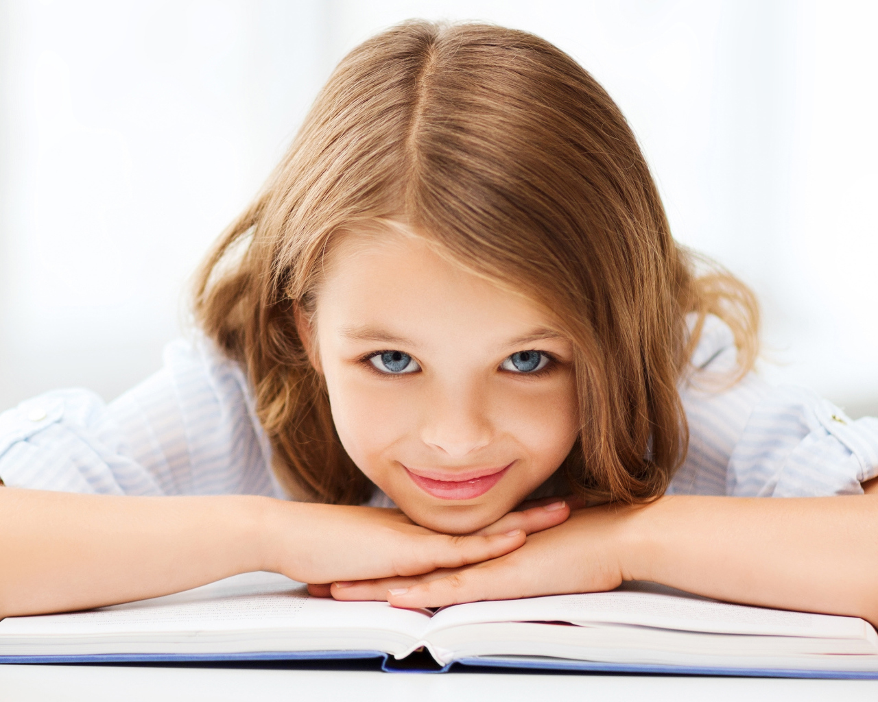 Маленькая голубоглазая девочка школьница с книгой 