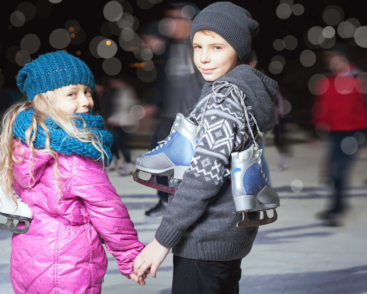 Маленькие мальчик и девочка на катке