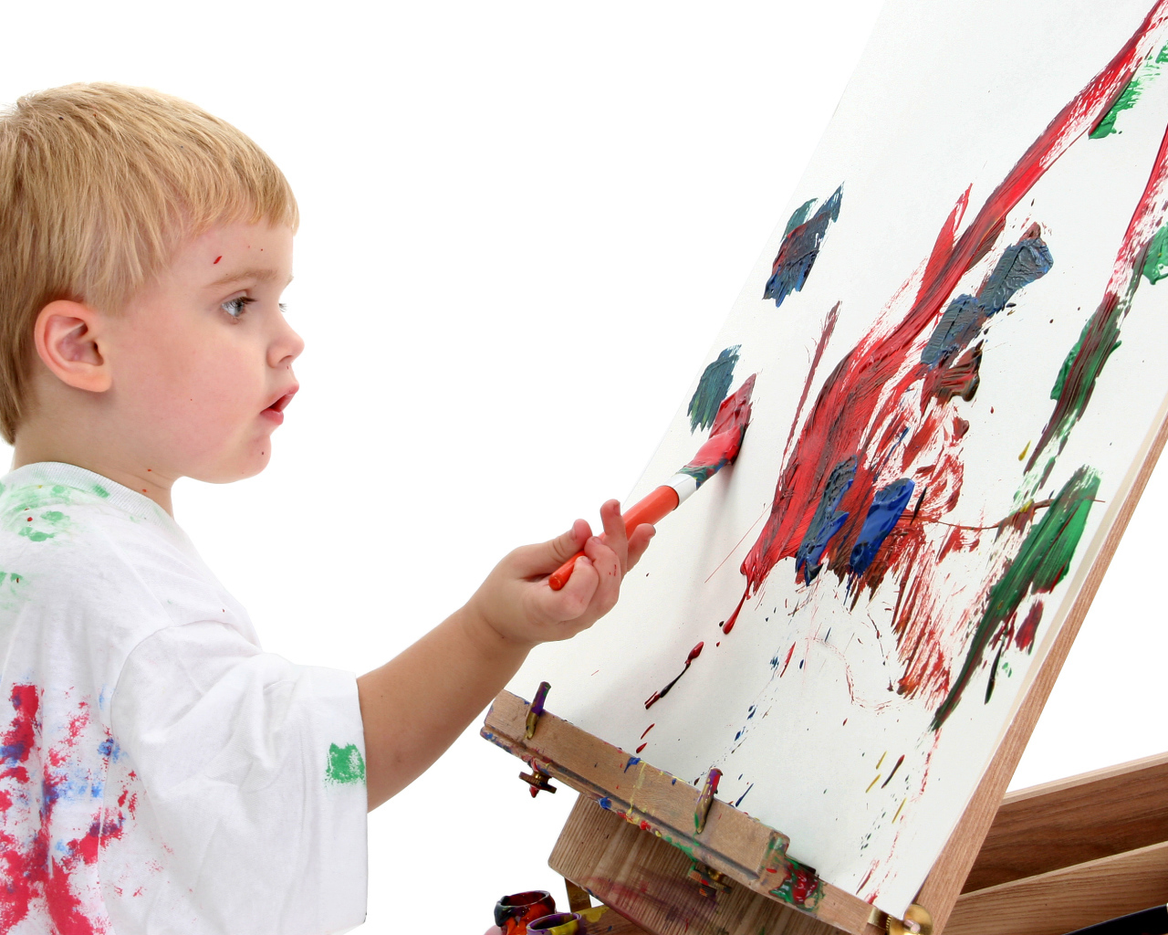 Маленький мальчик рисует красками 