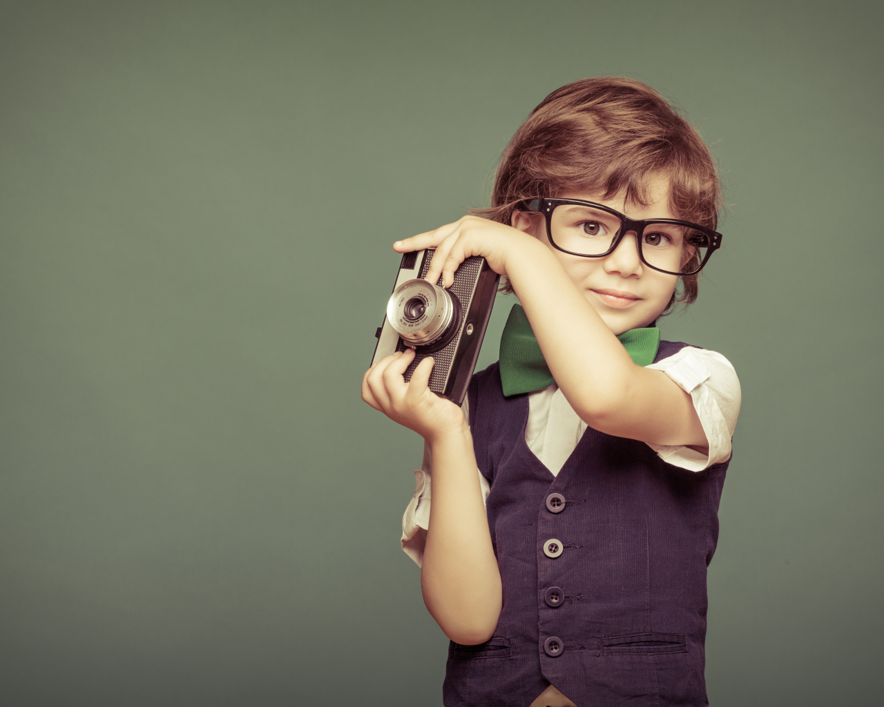Маленький мальчик в очках с фотоаппаратом