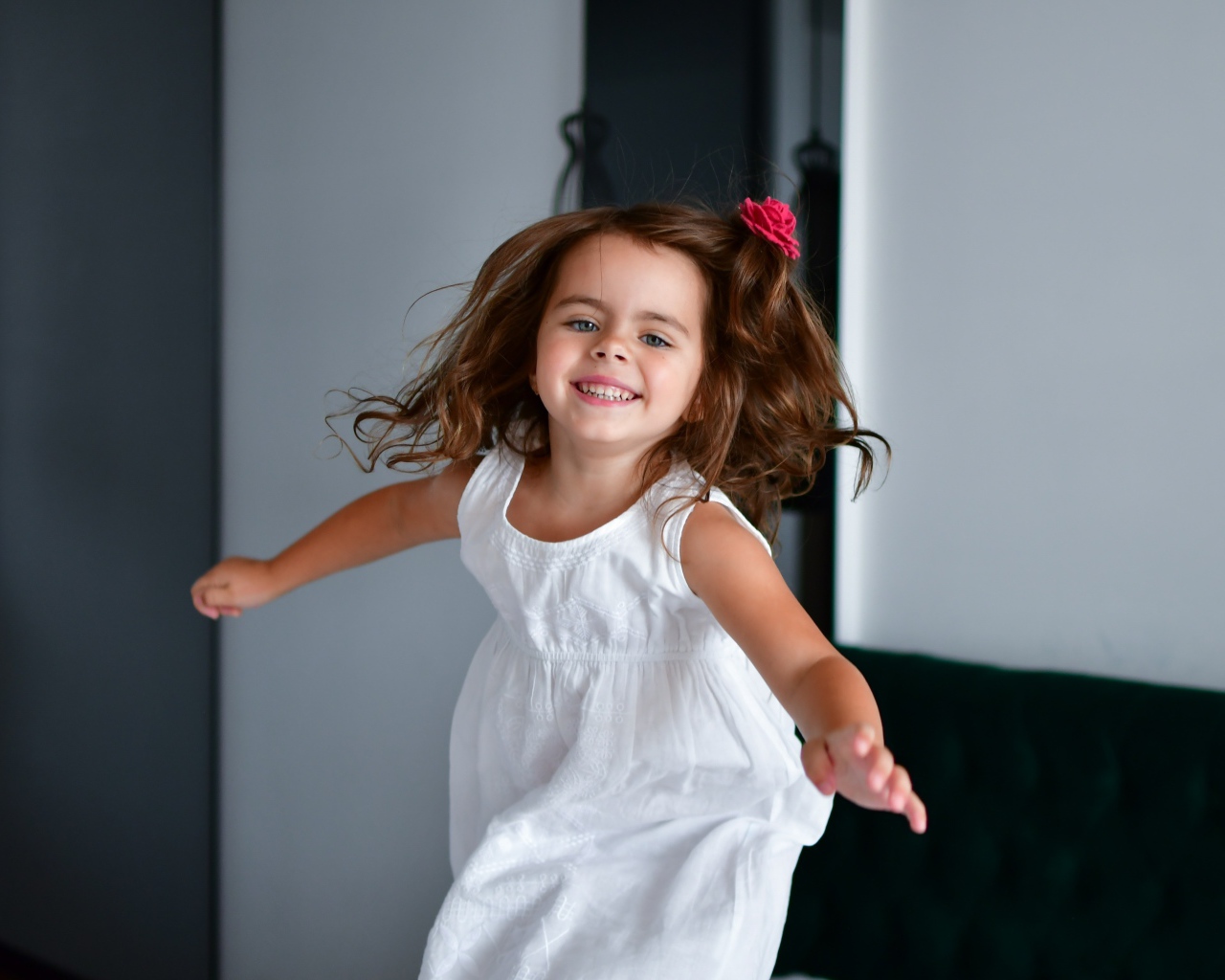 Маленькая веселая девочка в белом платье