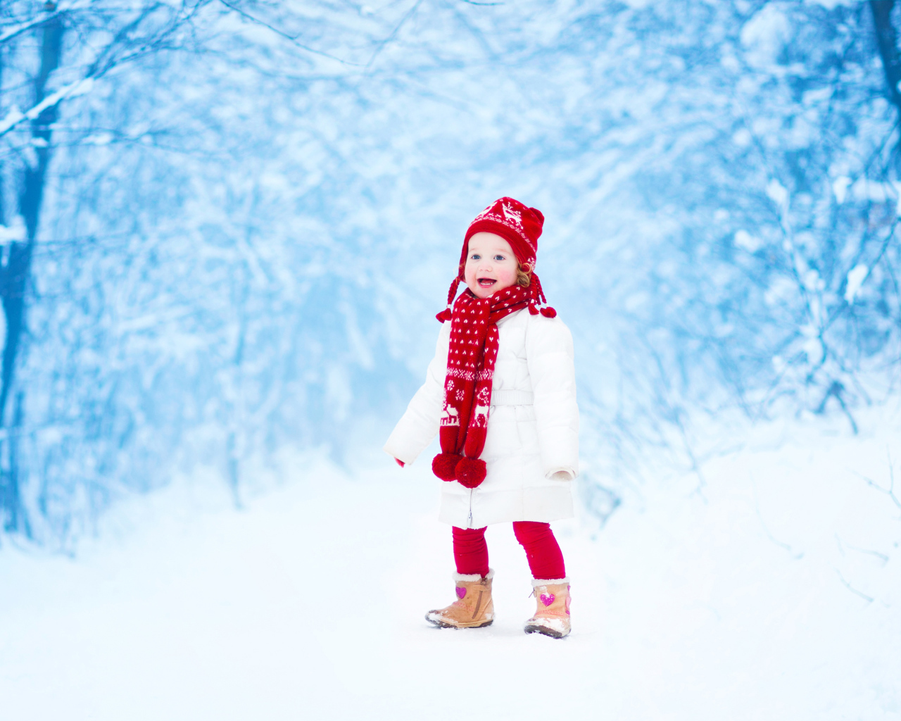 Маленькая веселая девочка в зимнем лесу