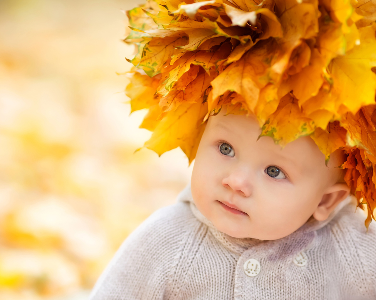 Маленький милый ребенок с венком из желтых листьев на голове 