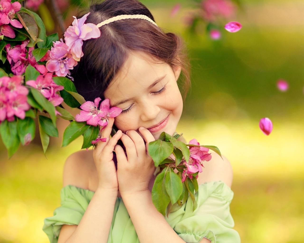 Маленькая девочка обнимает ветку с розовыми цветами