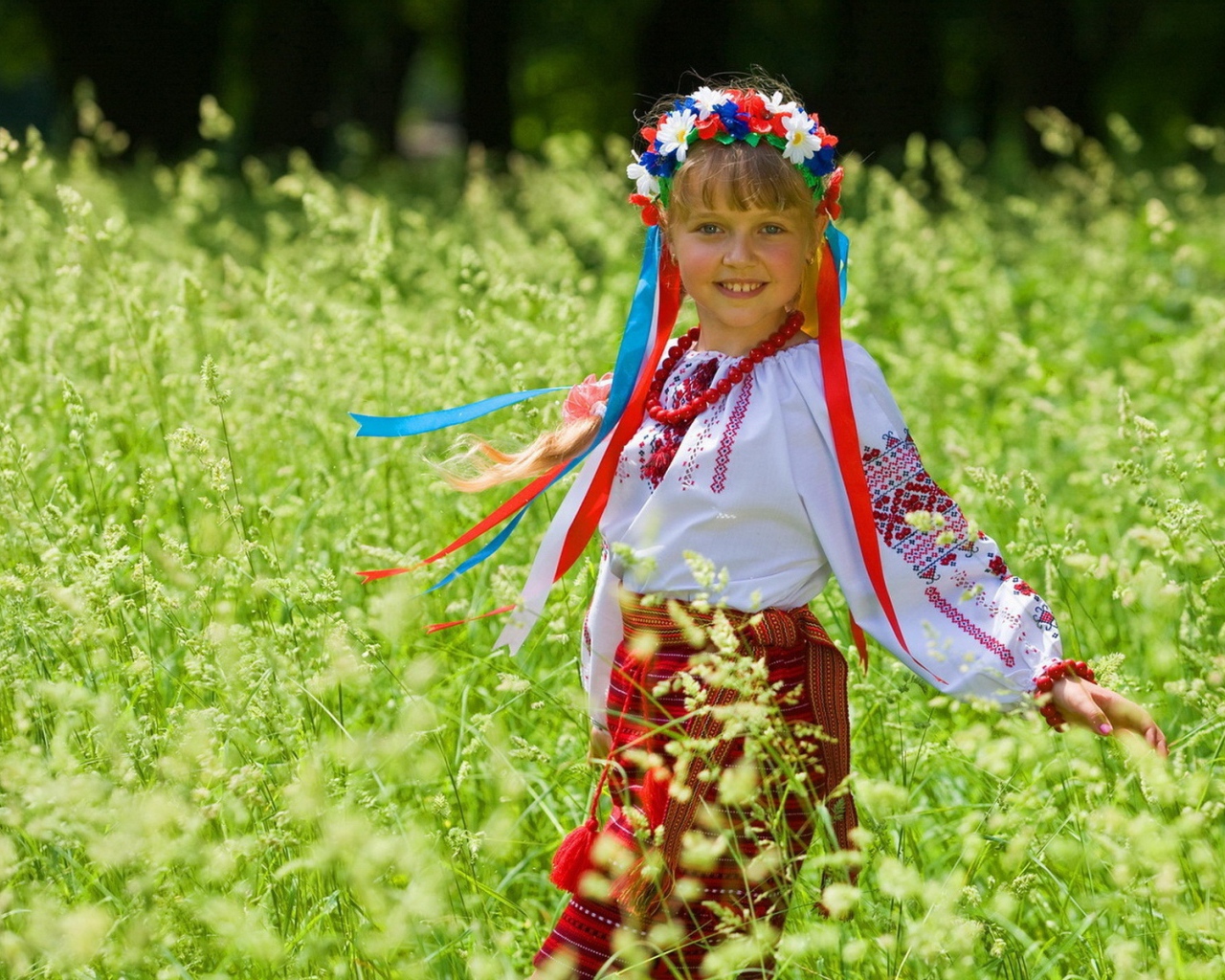 Маленькая девочка в костюме с венком на голове