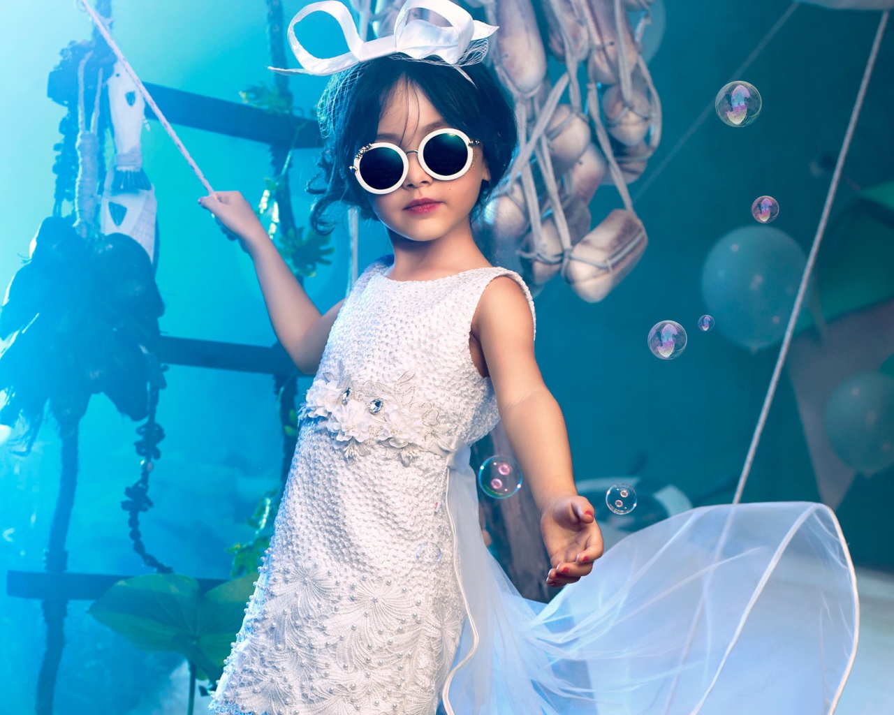 Маленькая девочка в белом платье и черных очках