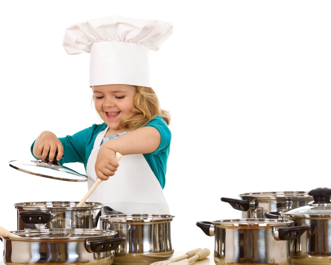 Маленькая девочка в костюме повара на кухне