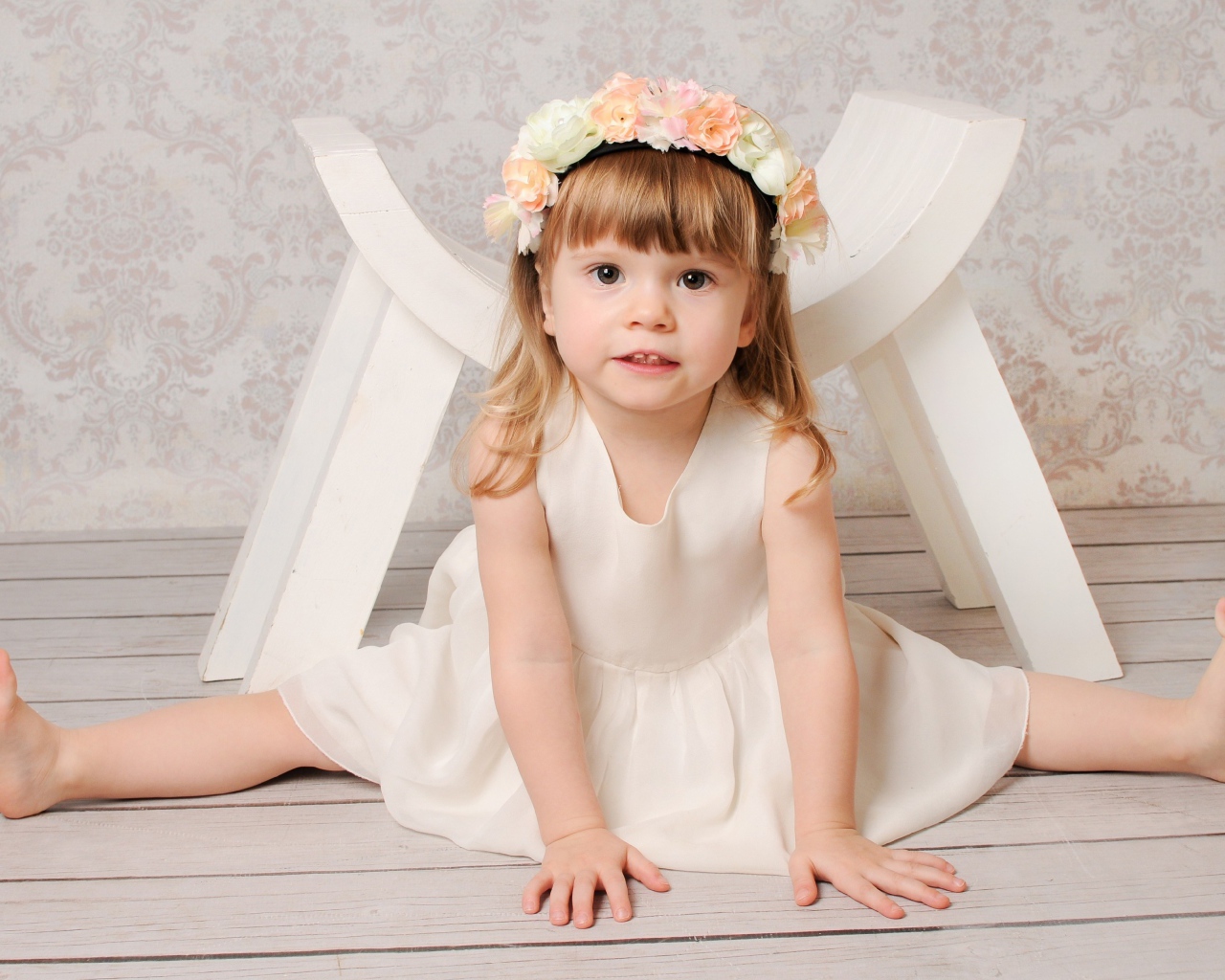 Маленькая девочка сидит на шпагате