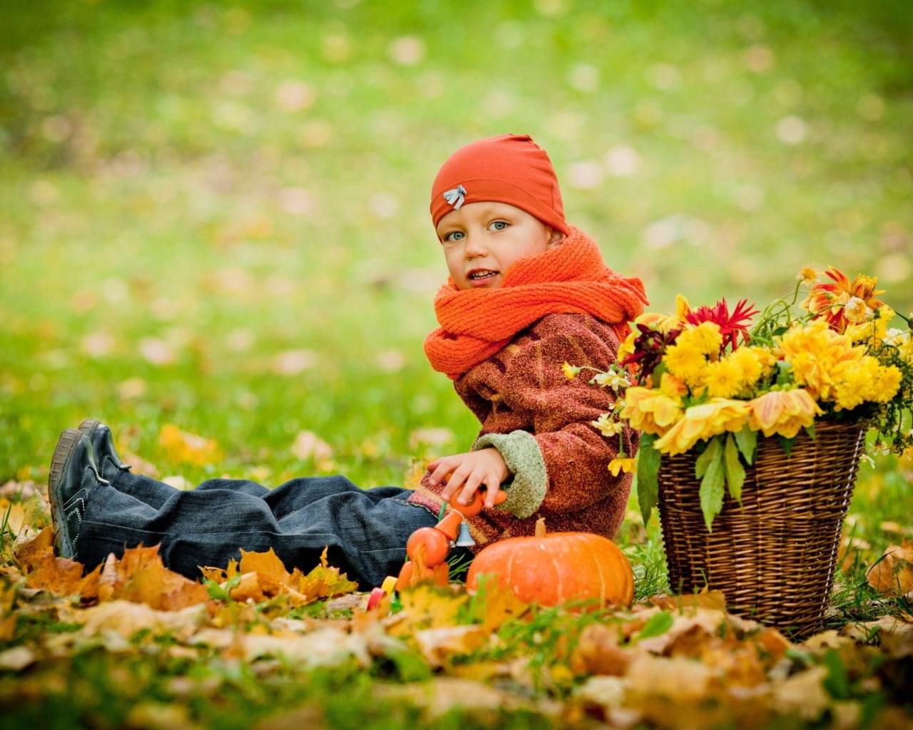 Маленькая девочка сидит на траве с корзиной цветов осенью