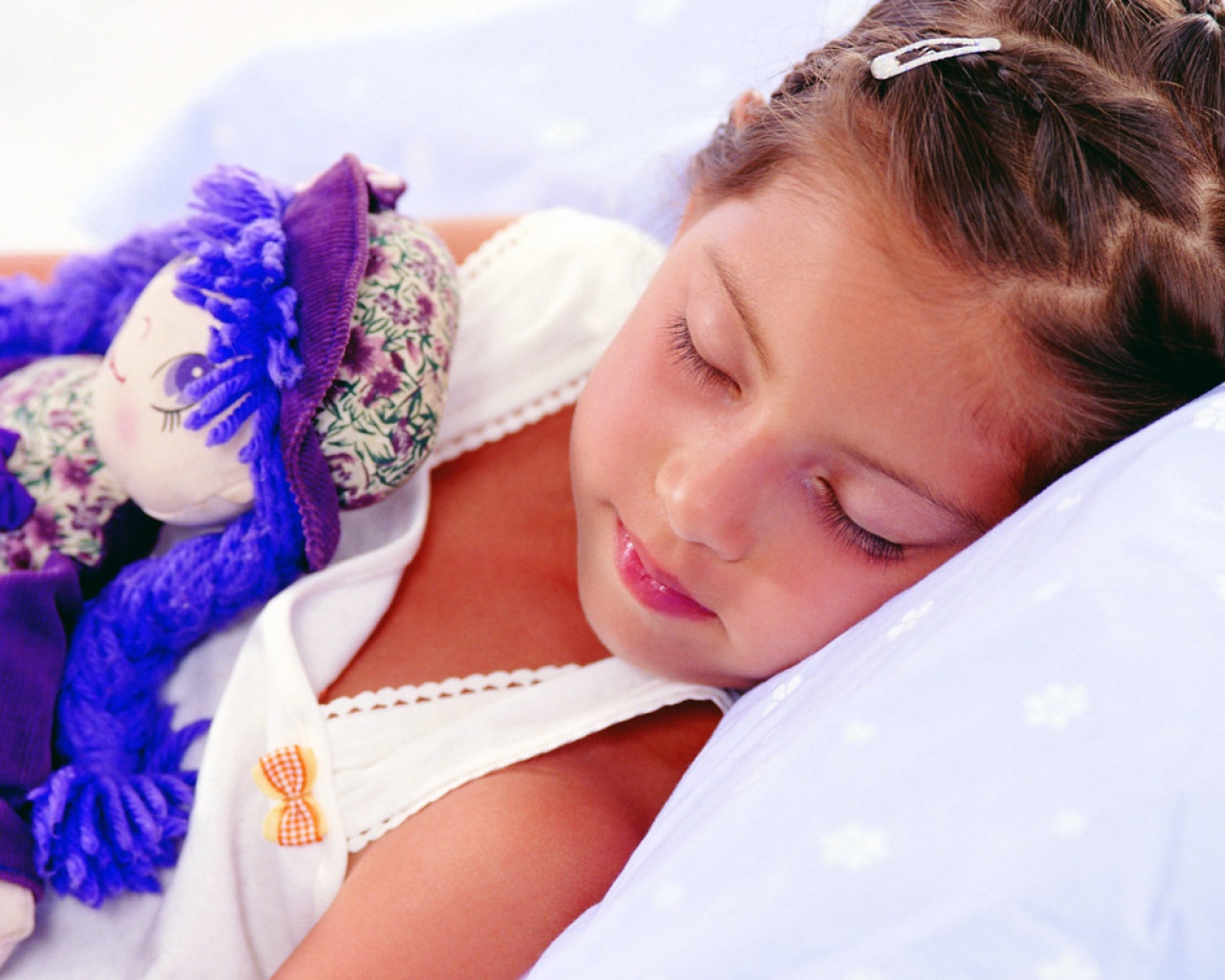 Маленькая девочка спит с игрушкой