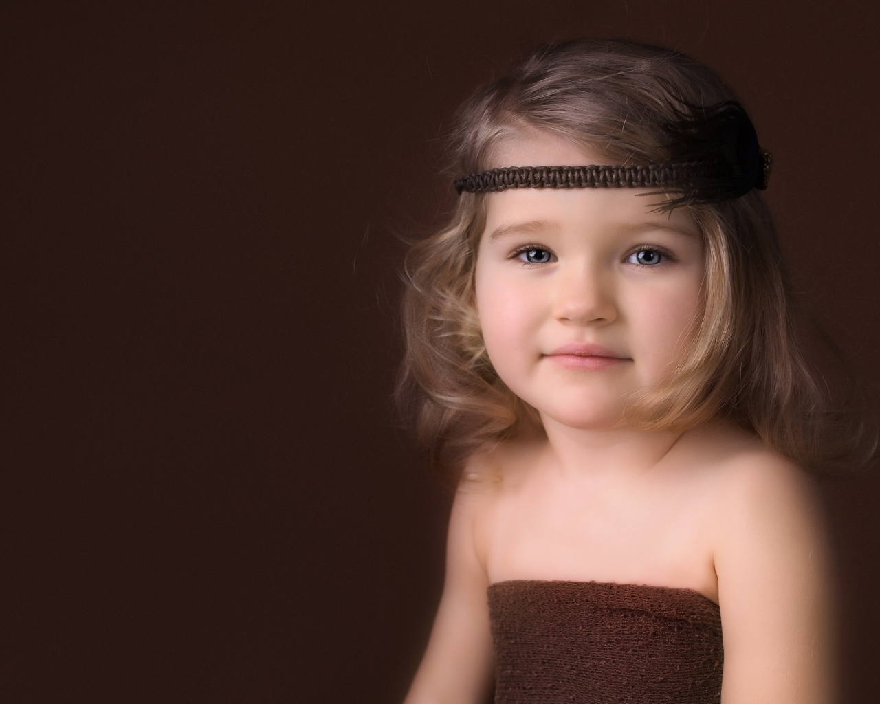 Маленькая девочка с повязкой на голове фото на коричневом фоне