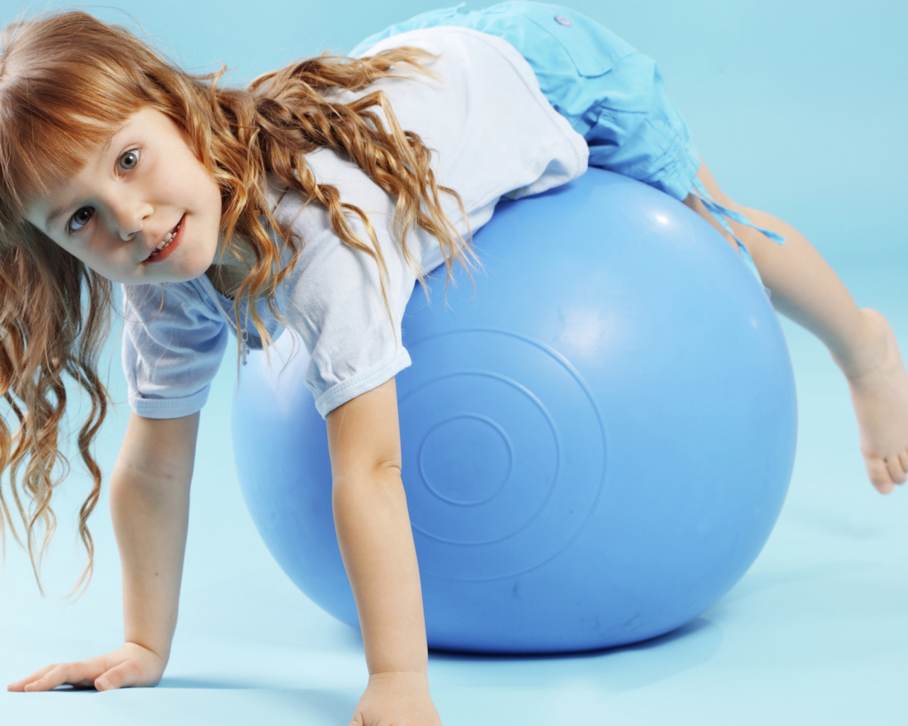 Маленькая девочка с большим голубым мячом