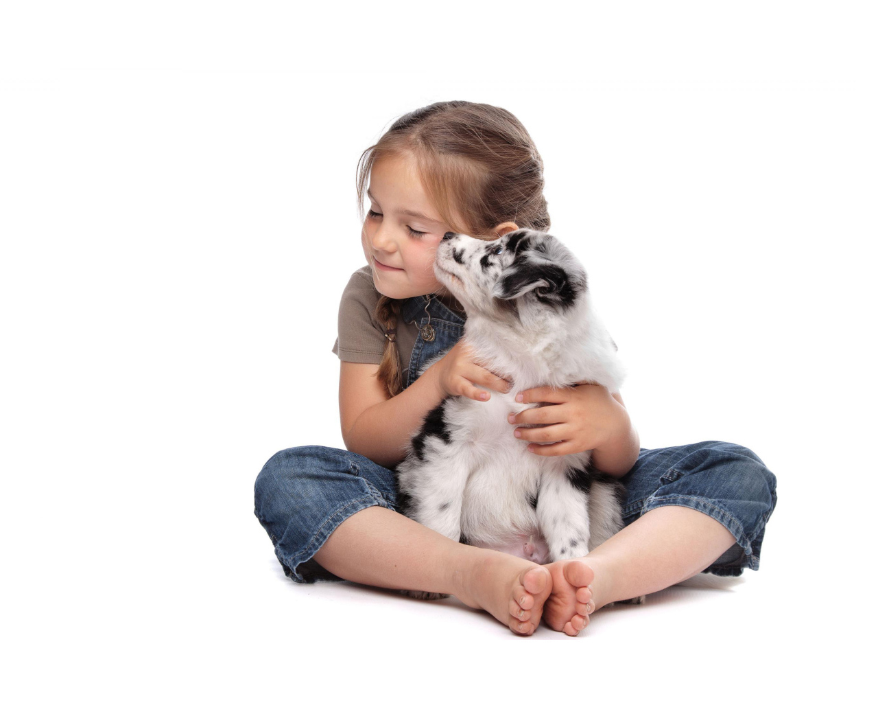 Маленькая девочка с щенком на белом фоне