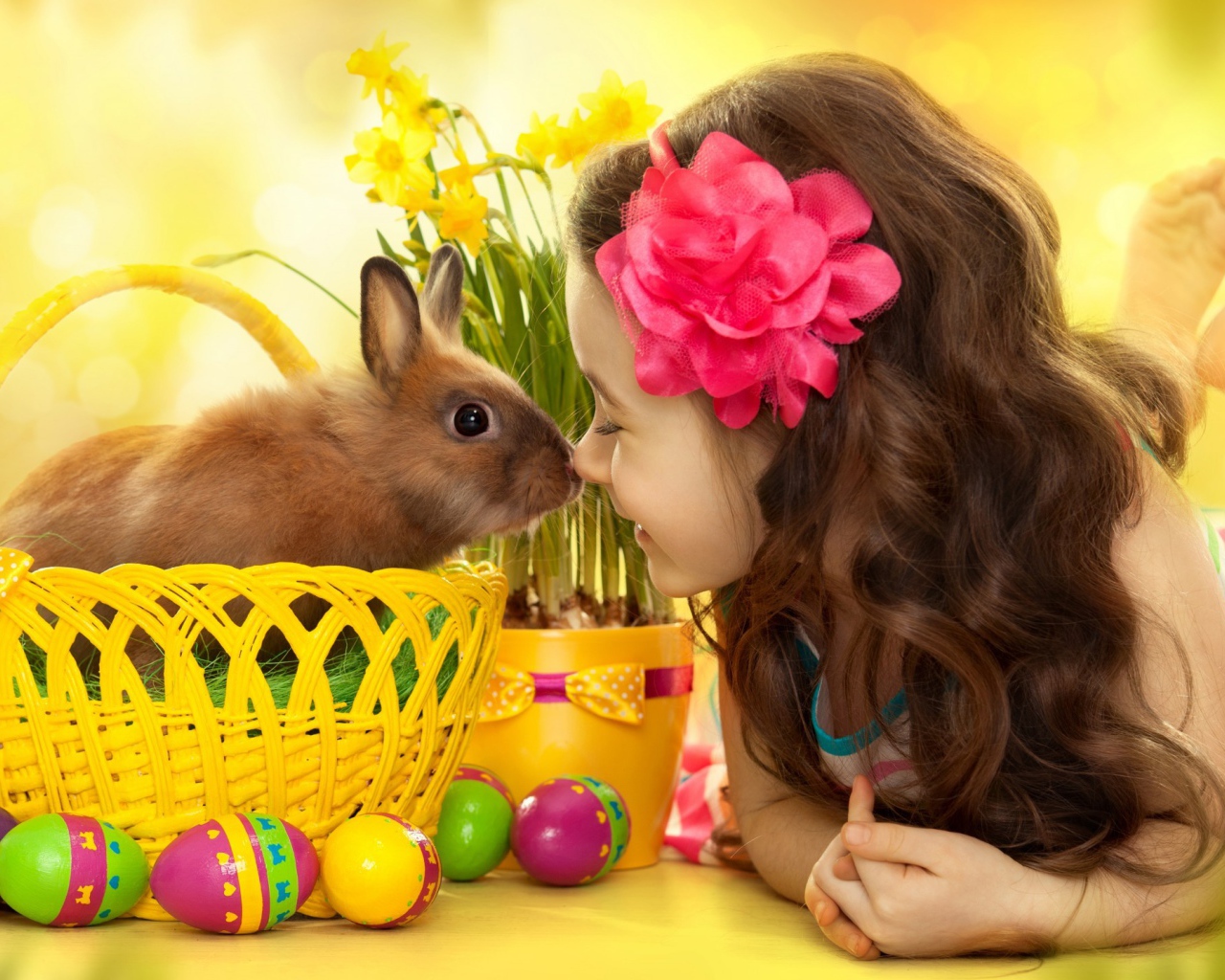 Маленькая девочка с кроликом в корзине на праздник Пасха