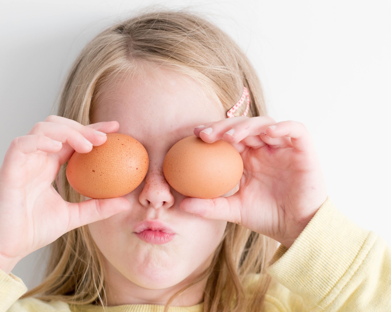 Маленькая девочка с яйцами в руках