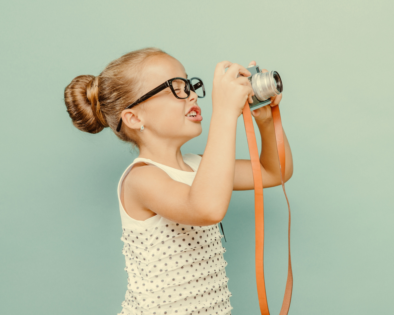 Маленькая девочка в очках с фотоаппаратом