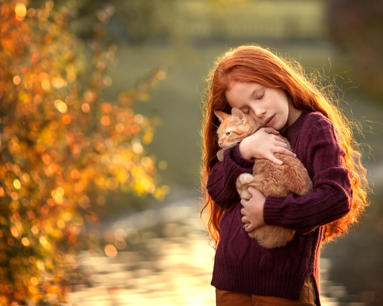 Маленькая рыжеволосая девочка с котенком на руках
