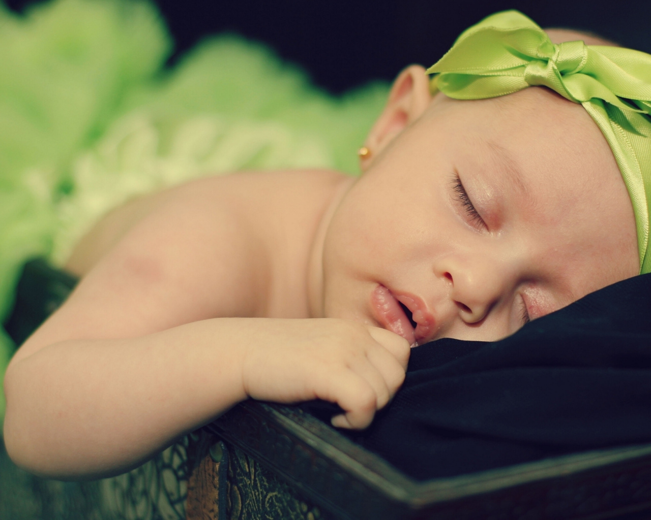 Маленькая спящая девочка с ленточкой на голове