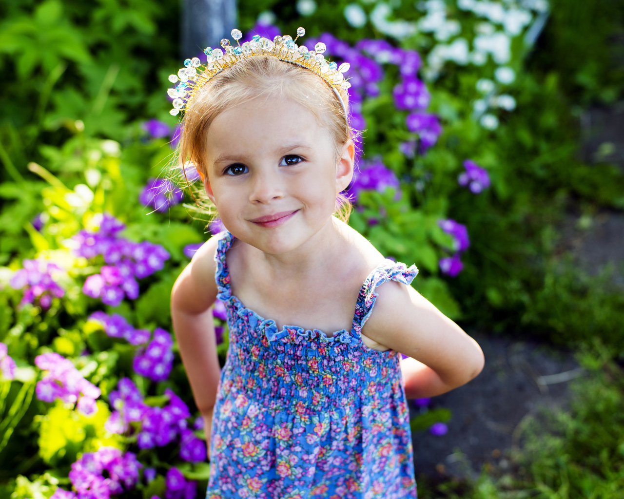 Маленькая улыбающаяся девочка с украшением в волосах 