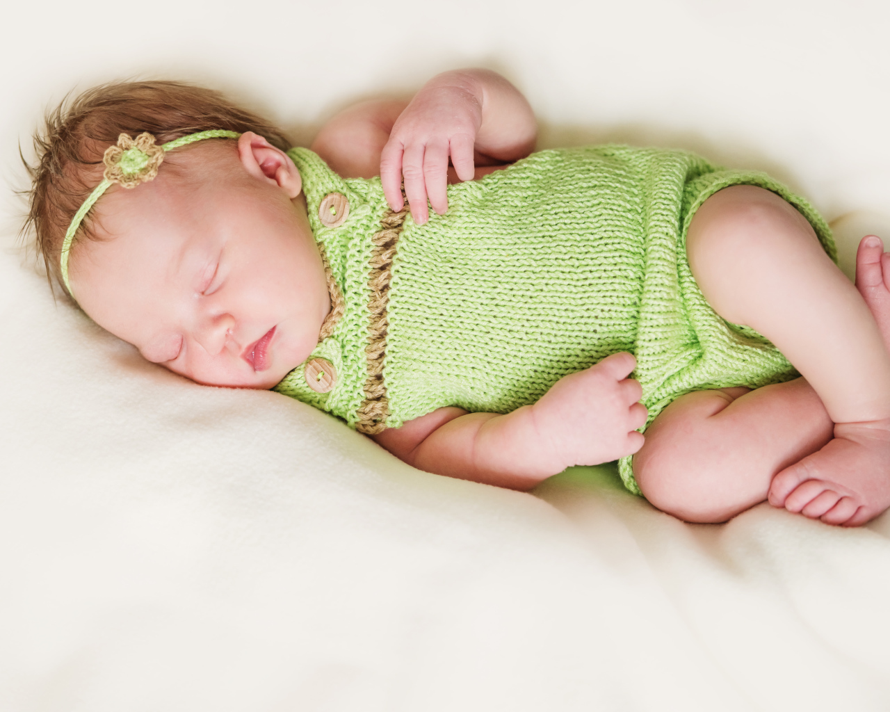 Спящий младенец в вязаной одежде