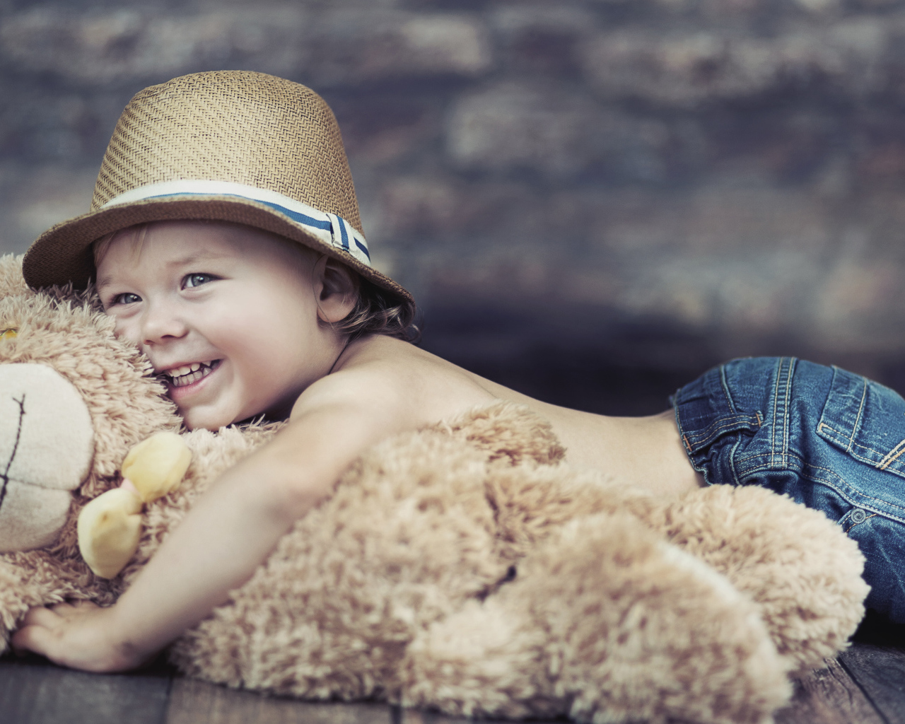 Улыбающийся мальчик обнимает игрушку