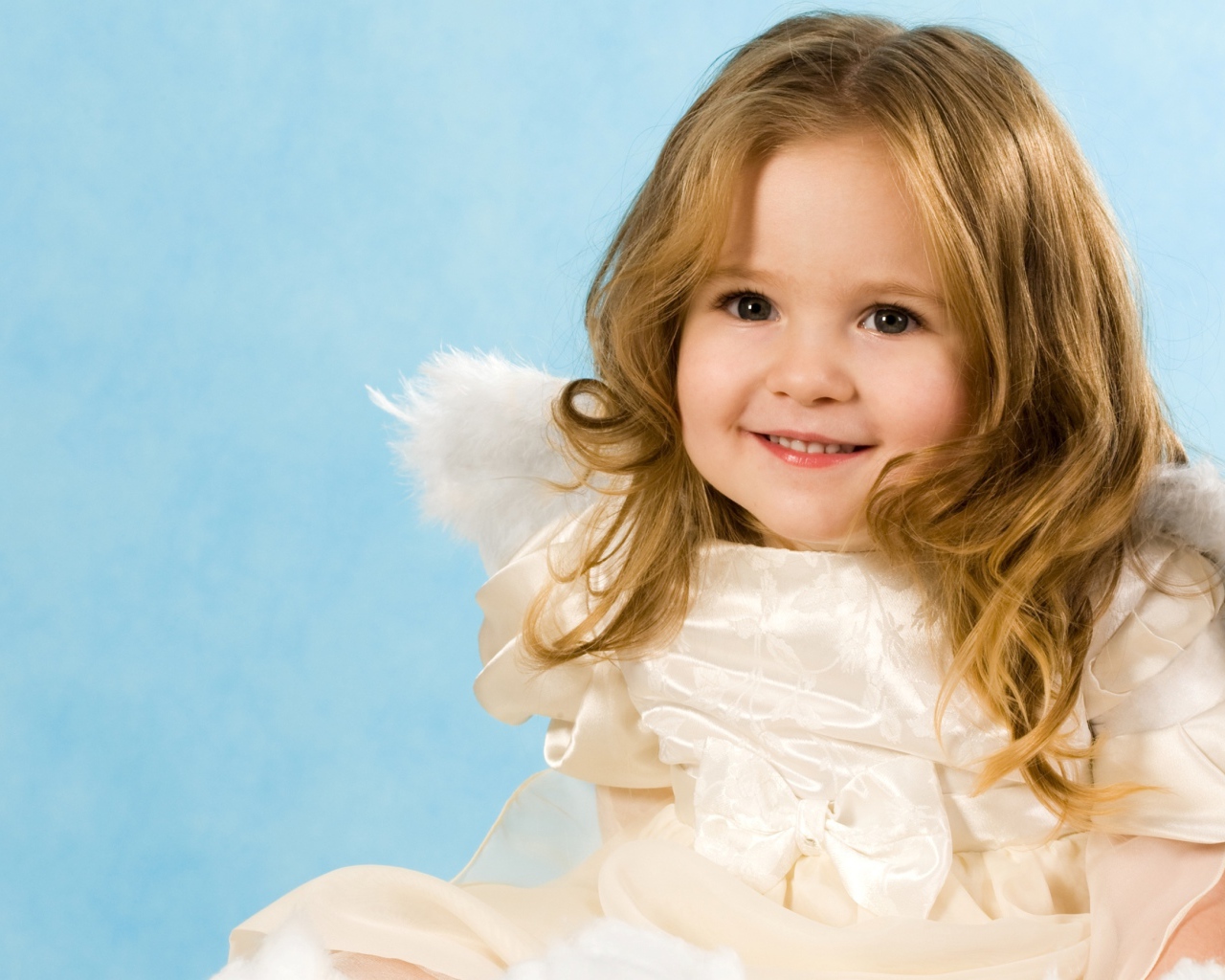 Улыбающаяся девочка с крыльями ангела