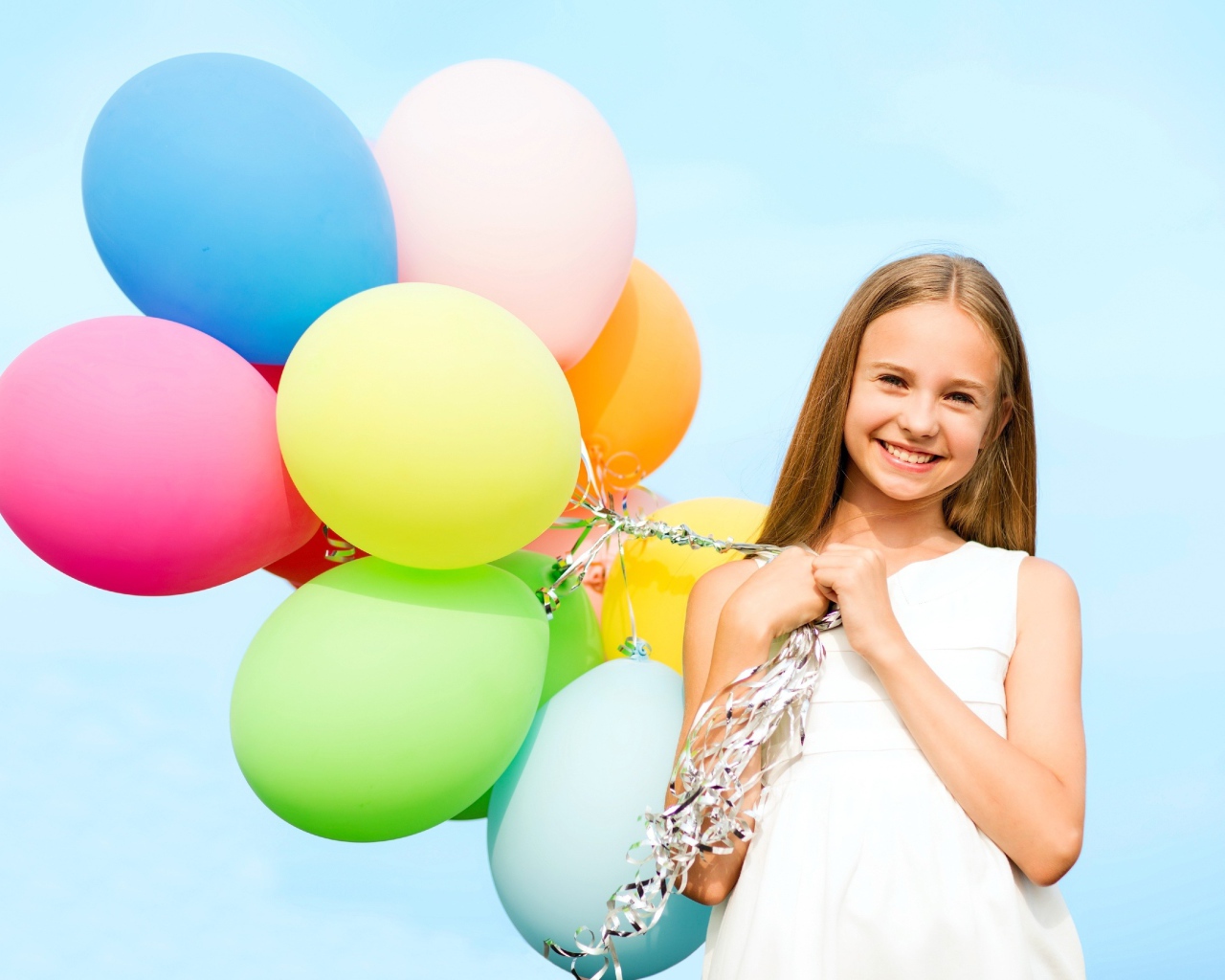 Улыбающаяся девочка с воздушными шарами