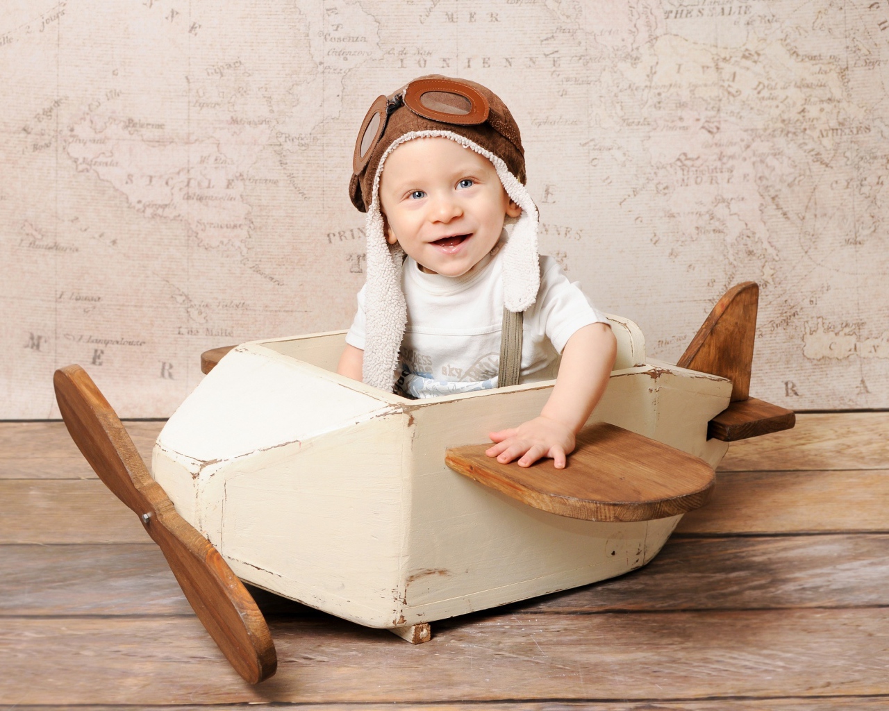 Улыбающийся маленький мальчик в игрушечном самолете