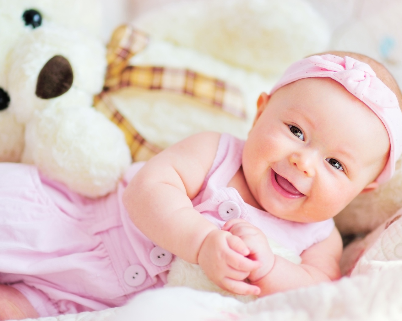 Улыбающаяся маленькая девочка с большим плюшевым медведем