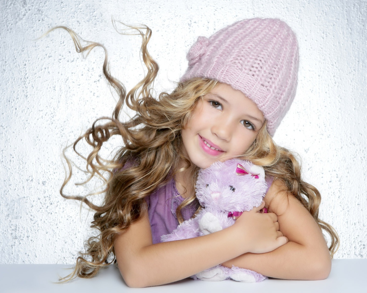 Милая светловолосая девочка с игрушкой