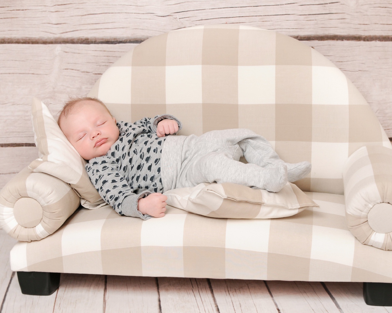 Грудной ребенок спит на диване