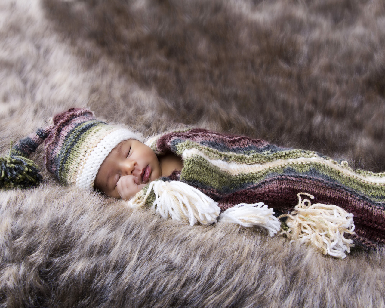 Младенец спит на меховом покрывале